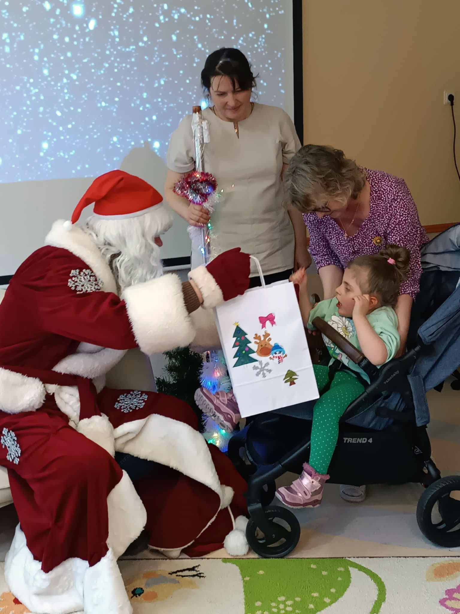 Nikolaus mit Kind im Rollstuhl mit grüner Kleidung
