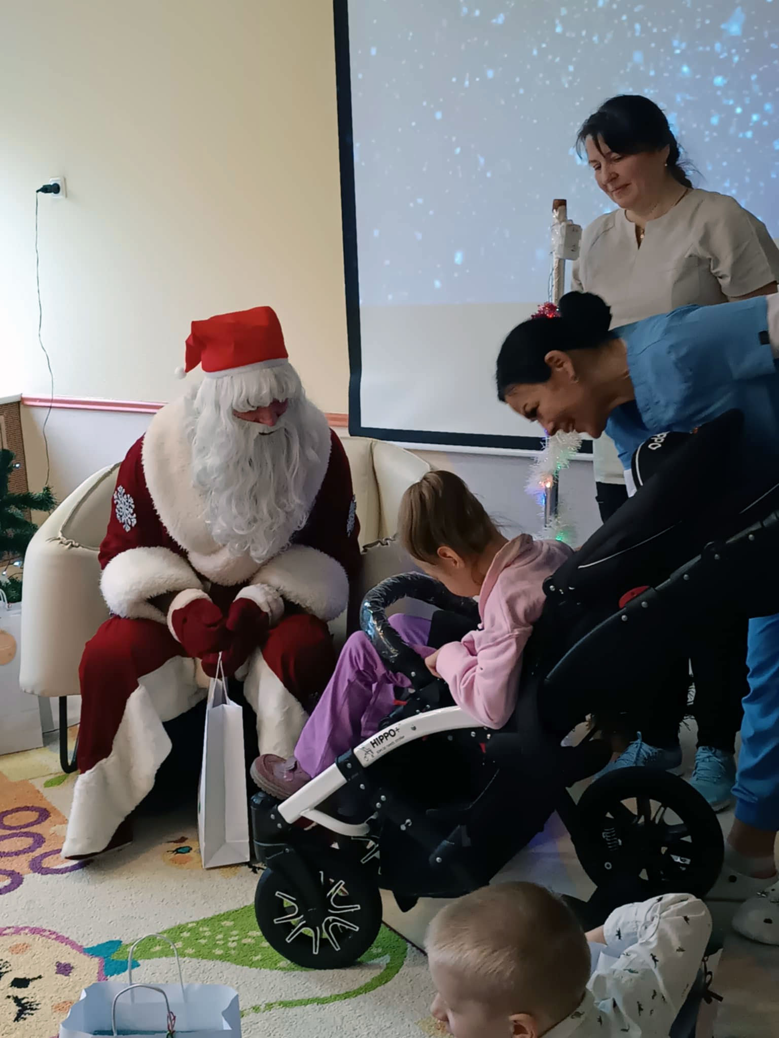Nikolaus mit Kind im Rollstuhl mit rosa-lila Kleidung